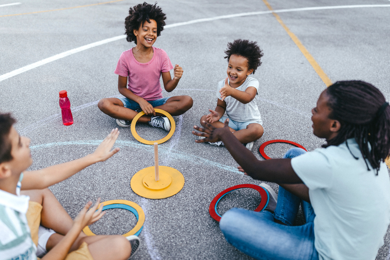 Woman with children playing ring toss game